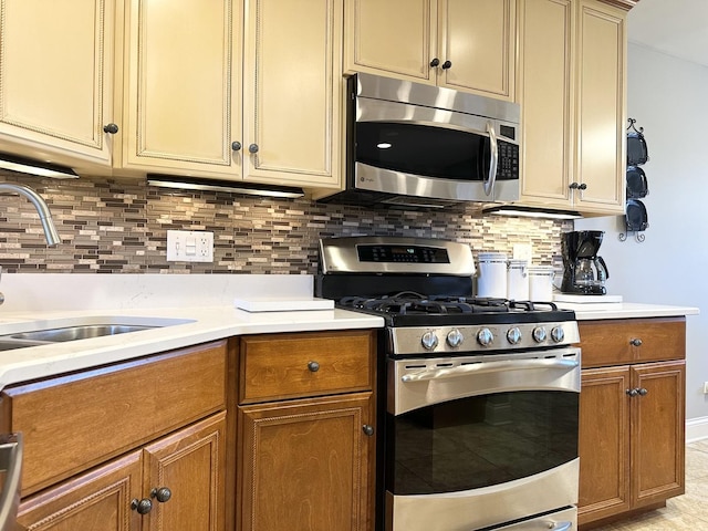 kitchen featuring stainless steel appliances, brown cabinets, light countertops, and a sink