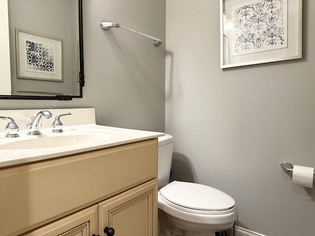 half bath featuring vanity and toilet