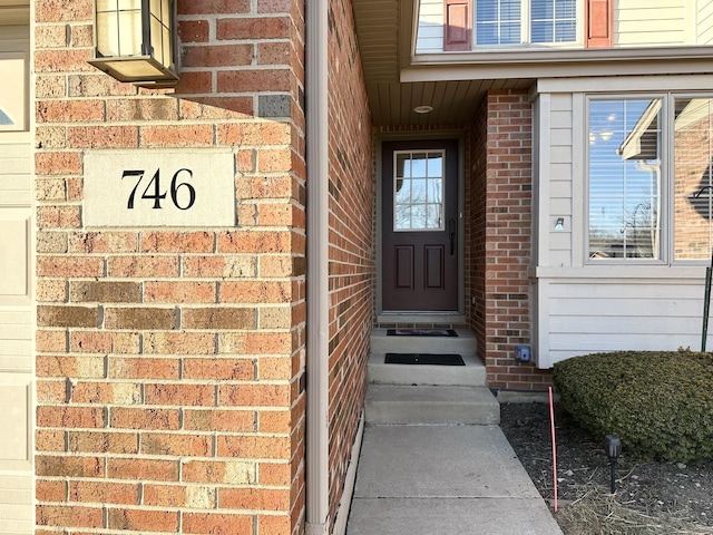 view of exterior entry featuring brick siding