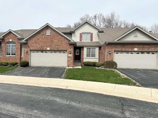 traditional-style home with roof with shingles, aphalt driveway, brick siding, and an attached garage