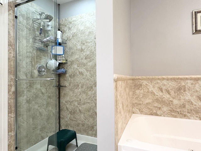 full bath featuring a stall shower and a garden tub