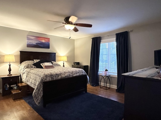 bedroom featuring baseboards, a ceiling fan, and wood finished floors