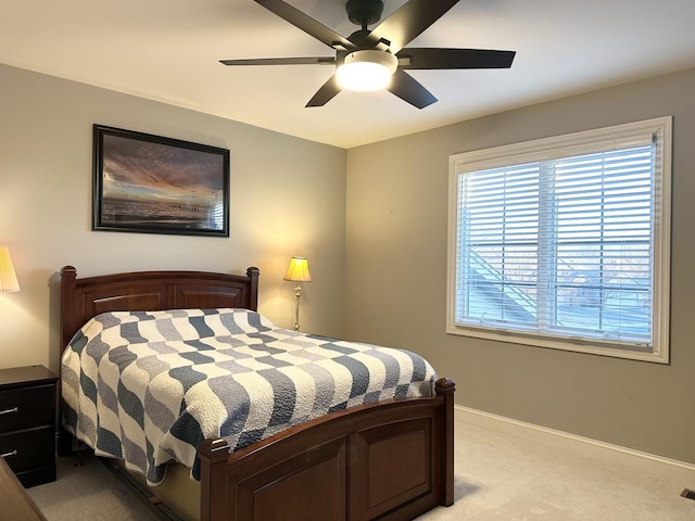 bedroom with light carpet, baseboards, and a ceiling fan