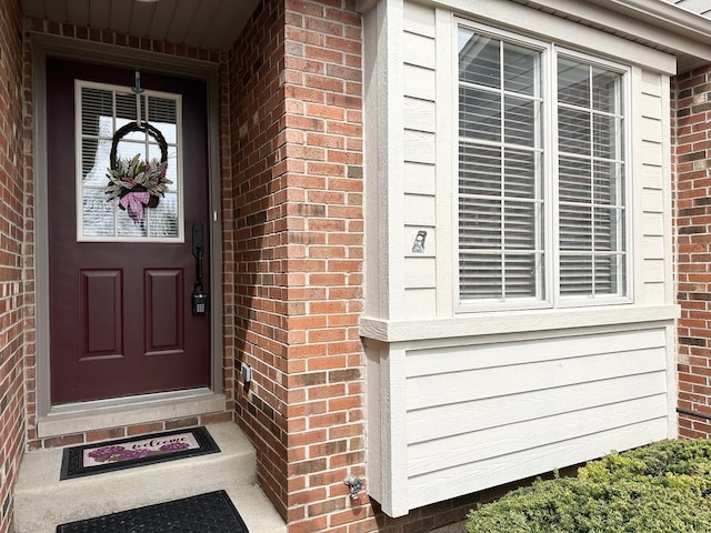 view of exterior entry with brick siding
