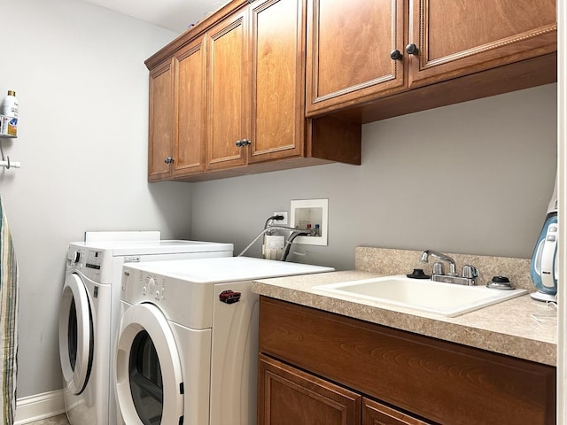 washroom featuring washing machine and dryer, a sink, and cabinet space