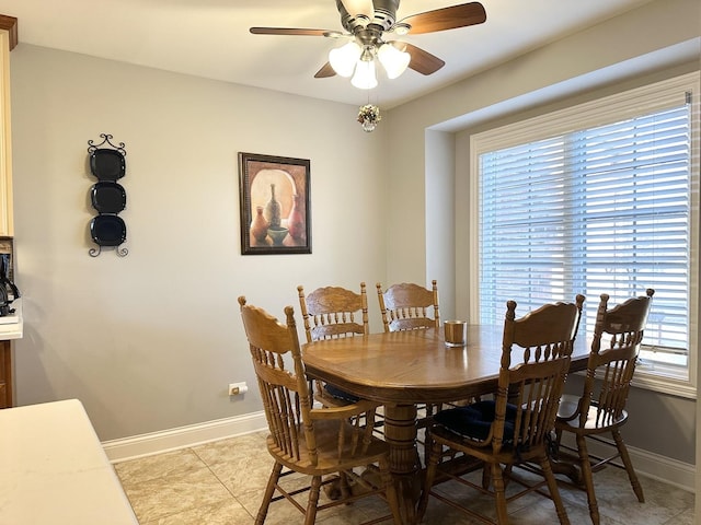 dining room with light tile patterned floors, baseboards, and a ceiling fan