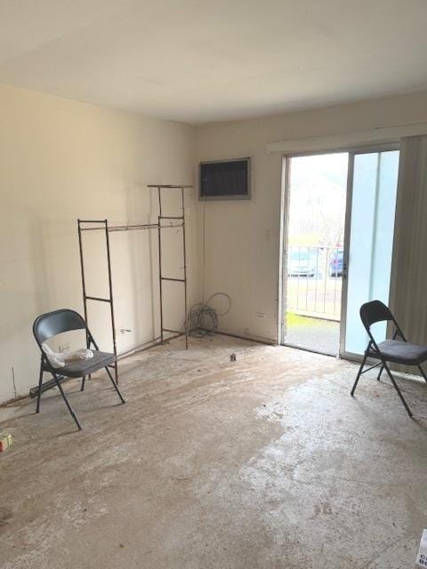 unfurnished room with unfinished concrete flooring and a wall mounted air conditioner