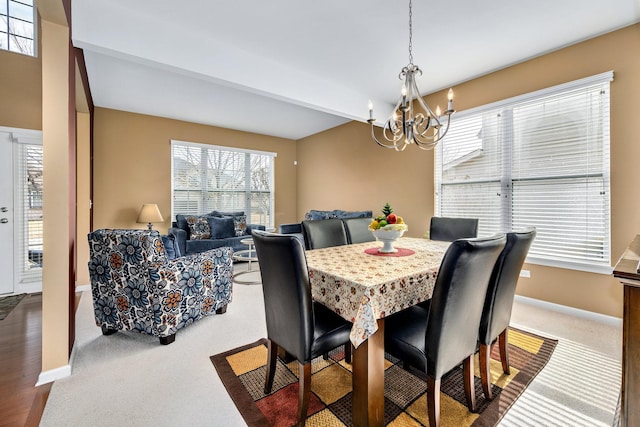 dining space featuring a notable chandelier, carpet, and baseboards