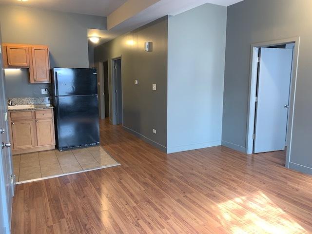 kitchen featuring baseboards, freestanding refrigerator, and light wood-style floors