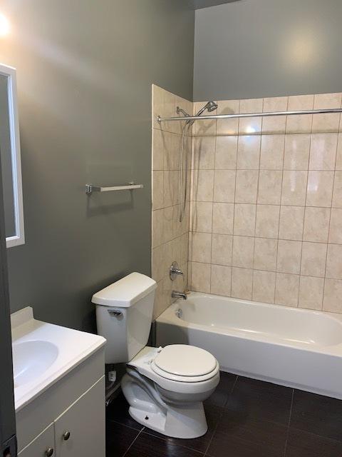 bathroom featuring bathtub / shower combination, vanity, toilet, and tile patterned floors