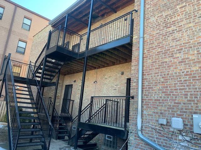 view of side of property featuring brick siding and stairs