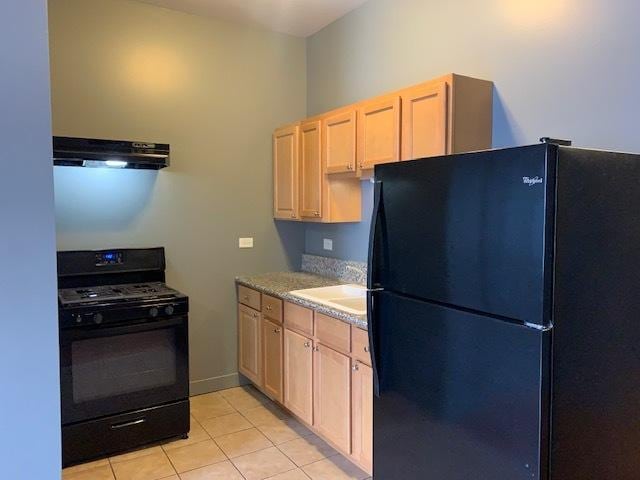 kitchen with extractor fan, light tile patterned flooring, a sink, light brown cabinetry, and black appliances