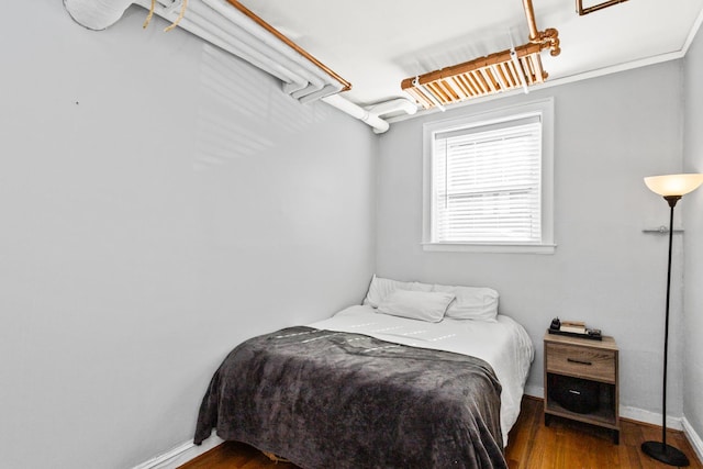 bedroom with baseboards and wood finished floors