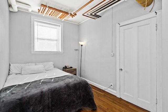 bedroom with baseboards and wood finished floors