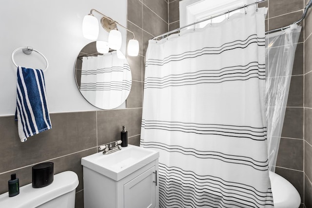 full bath featuring a shower with shower curtain, tile walls, toilet, and vanity