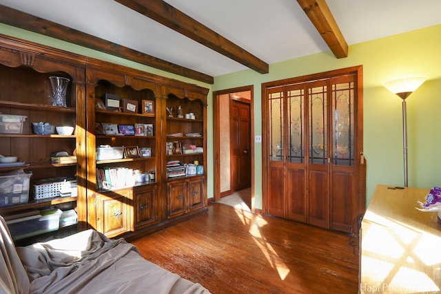 living area with dark wood-style flooring and beam ceiling