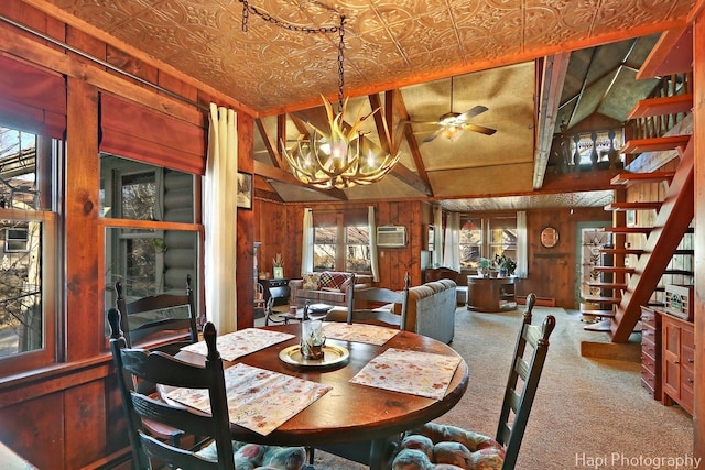 carpeted dining area featuring stairs, wood walls, lofted ceiling, and an ornate ceiling