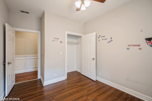 unfurnished bedroom with visible vents, dark wood-type flooring, baseboards, a closet, and a ceiling fan