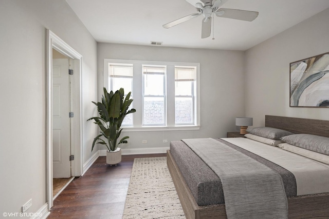 bedroom with a ceiling fan, dark wood-style floors, visible vents, and baseboards