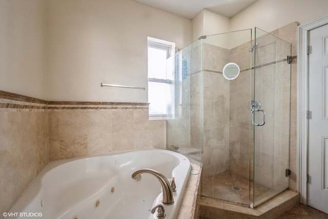 bathroom featuring a shower stall and a jetted tub