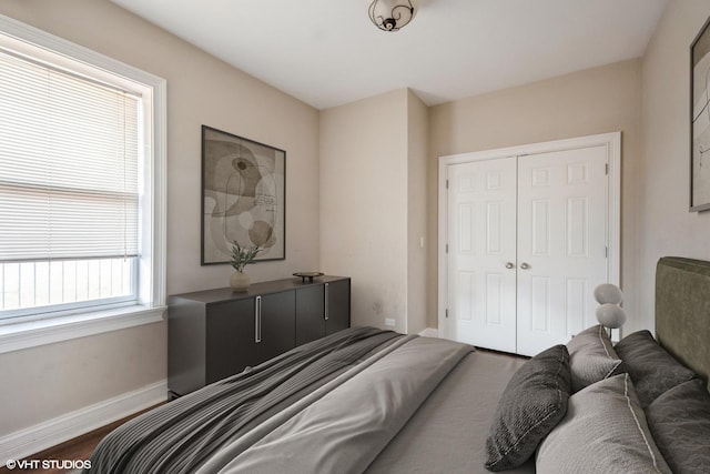 bedroom with a closet, baseboards, and wood finished floors