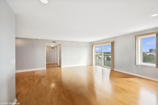 empty room featuring light wood-type flooring and baseboards