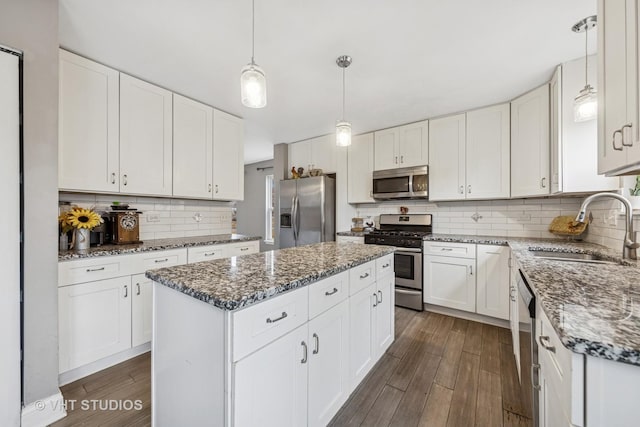 kitchen with tasteful backsplash, dark wood finished floors, stainless steel appliances, and a sink