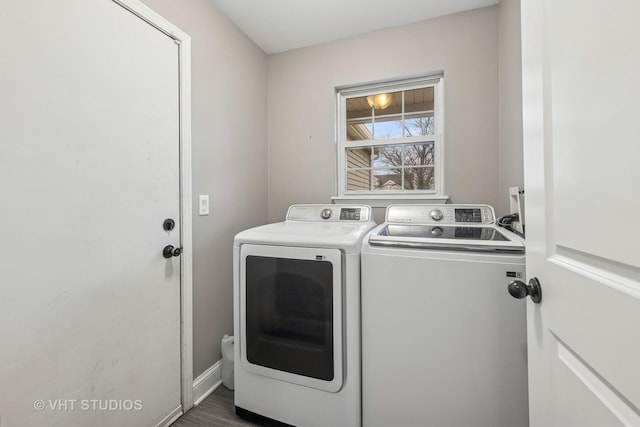 clothes washing area featuring washing machine and dryer, laundry area, and baseboards