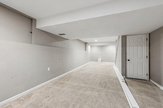 finished below grade area featuring carpet floors, baseboards, and visible vents