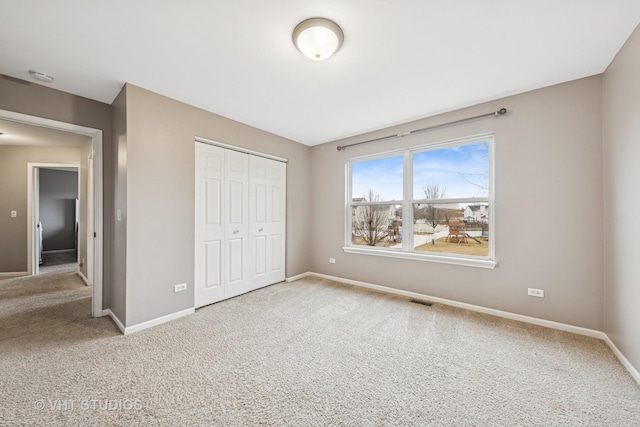 unfurnished bedroom featuring carpet floors, a closet, and baseboards