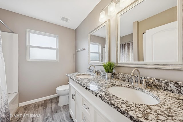 full bathroom with a wealth of natural light, wood finished floors, a sink, and visible vents