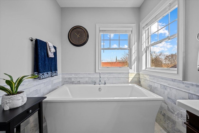 full bath with vanity, tile walls, wainscoting, and a freestanding bath