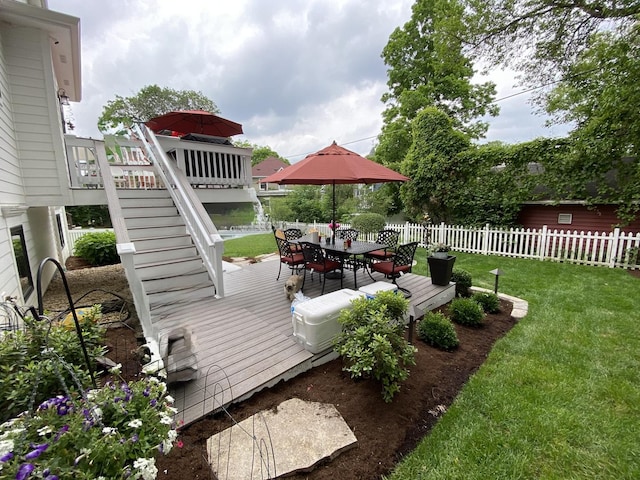 wooden terrace featuring stairs, outdoor dining space, fence, and a lawn