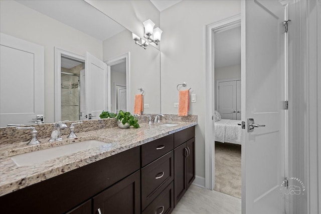 ensuite bathroom with double vanity, connected bathroom, a shower, and a sink