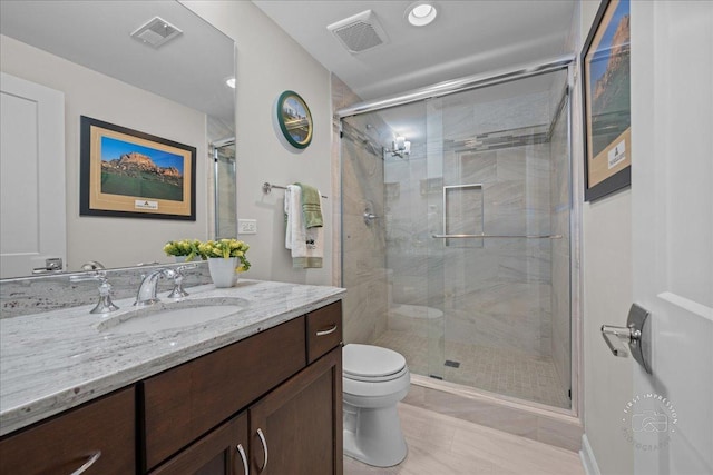 full bathroom featuring visible vents, a shower stall, toilet, and vanity