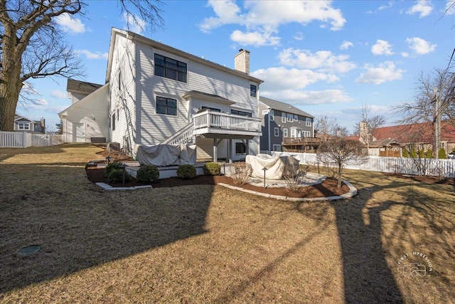 rear view of house with a yard, a chimney, a deck, and fence