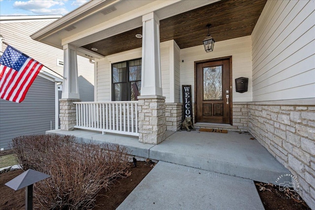 property entrance with stone siding and covered porch