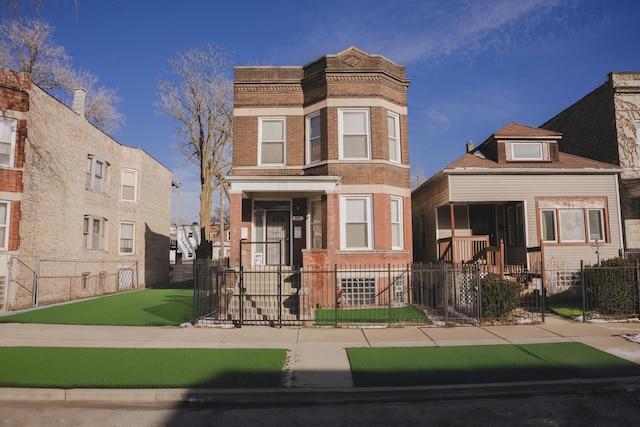 view of front facade with brick siding and a fenced front yard