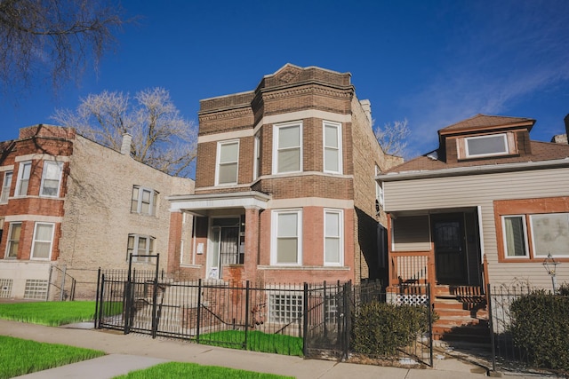 view of front of house featuring a fenced front yard, a gate, and brick siding