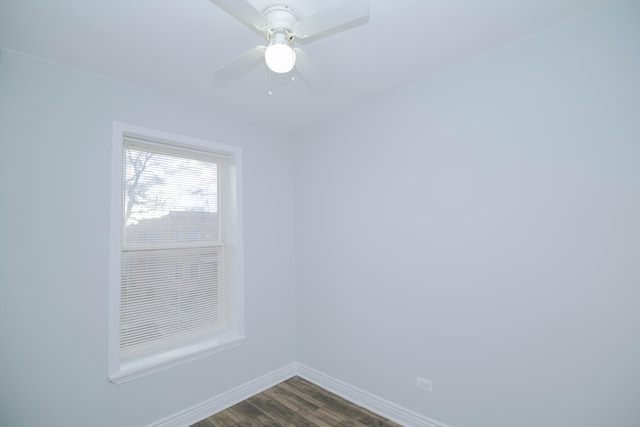 unfurnished room featuring dark wood-style flooring, a ceiling fan, and baseboards