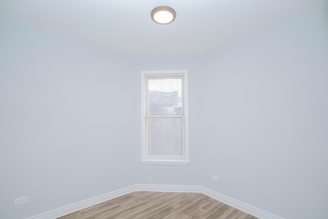 spare room featuring light wood-type flooring and baseboards