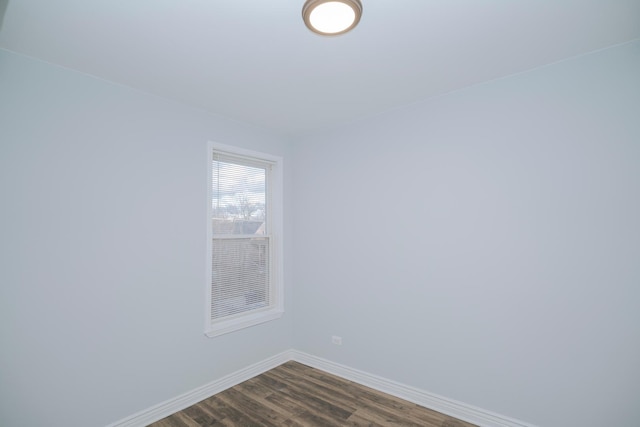 spare room with dark wood-style floors and baseboards