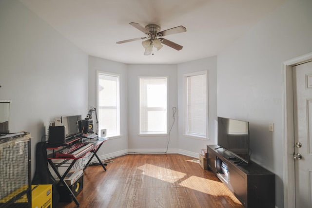 office area with ceiling fan, baseboards, and wood finished floors