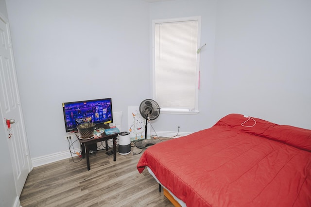 bedroom featuring baseboards and wood finished floors