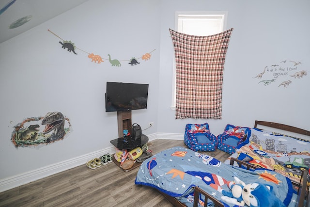 bedroom with baseboards and wood finished floors