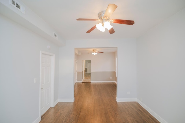 spare room with baseboards, visible vents, and wood finished floors