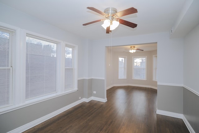 unfurnished room featuring baseboards and dark wood-style flooring