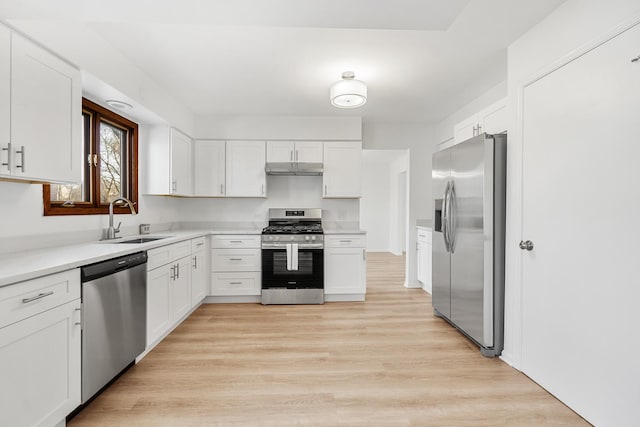 kitchen featuring appliances with stainless steel finishes, white cabinetry, and a sink