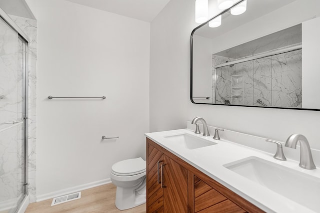 bathroom with a sink, visible vents, and a marble finish shower