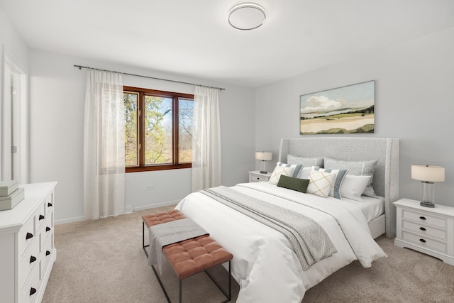 bedroom with baseboards and light colored carpet